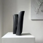 Profile view of Pendere abstract pear wood sculpture, where smooth charred planes partially conceal the textured interior.