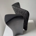 Top view of Pendere revealing its open central passage, curved black surfaces and hand-carved texture in charred pear wood.
