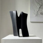 Front view of Pendere showing two rising charred pear wood forms connected through a deeply hand-textured central passage.