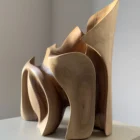 Side view of Unfurl organic walnut sculpture, showing overlapping carved planes and the sculptural movement of the solid wood form.