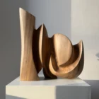 Rear angle of Unfurl, a hand-carved walnut sculpture with sweeping curves, carved openings and flowing organic plane