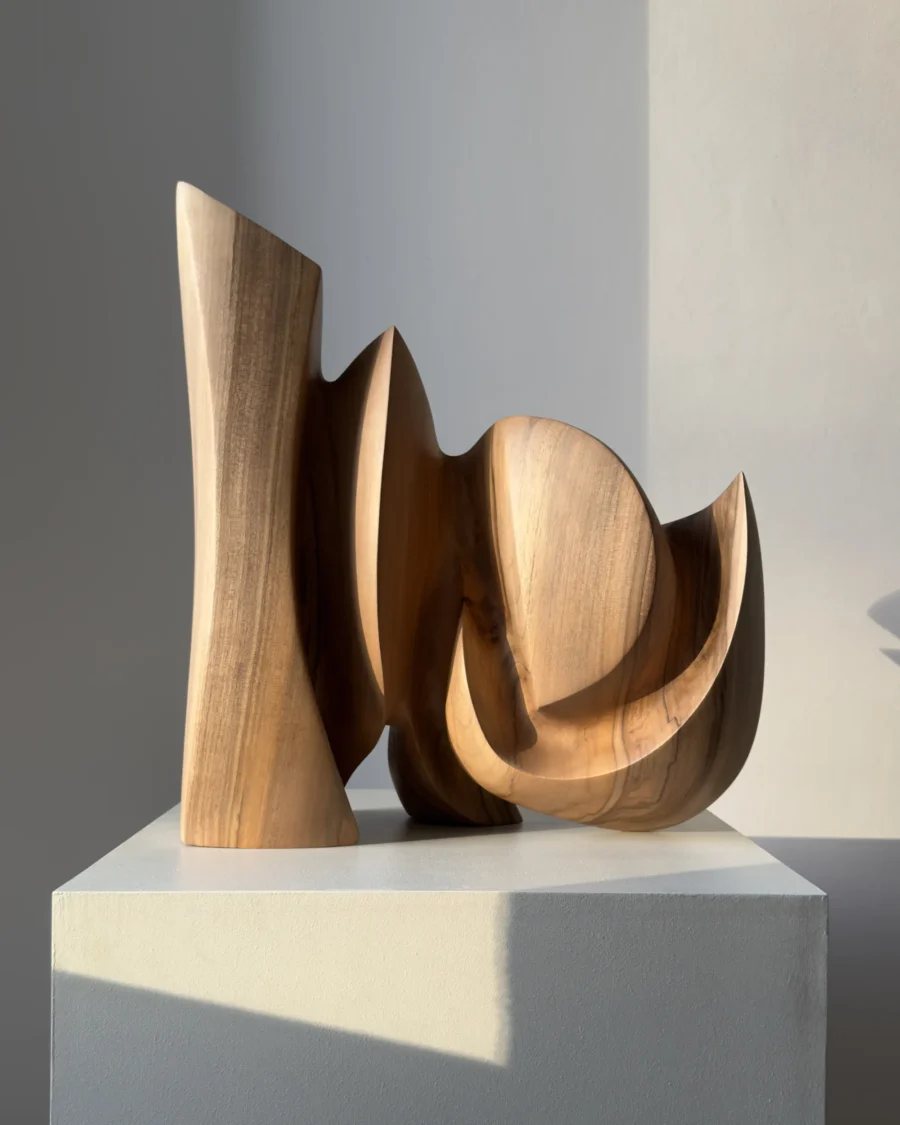 Rear angle of Unfurl, a hand-carved walnut sculpture with sweeping curves, carved openings and flowing organic plane