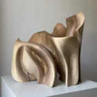 Front view of Unfurl walnut sculpture in natural light, revealing the rhythm of its upright carved planes and smooth walnut surfaces.
