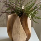 Close view of purple heather inside Within, surrounded by sweeping carved walnut surfaces and darker recessed areas.