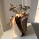 Within with a dried seed head in warm sunlight, highlighting the deep carved interior and sweeping walnut rim.