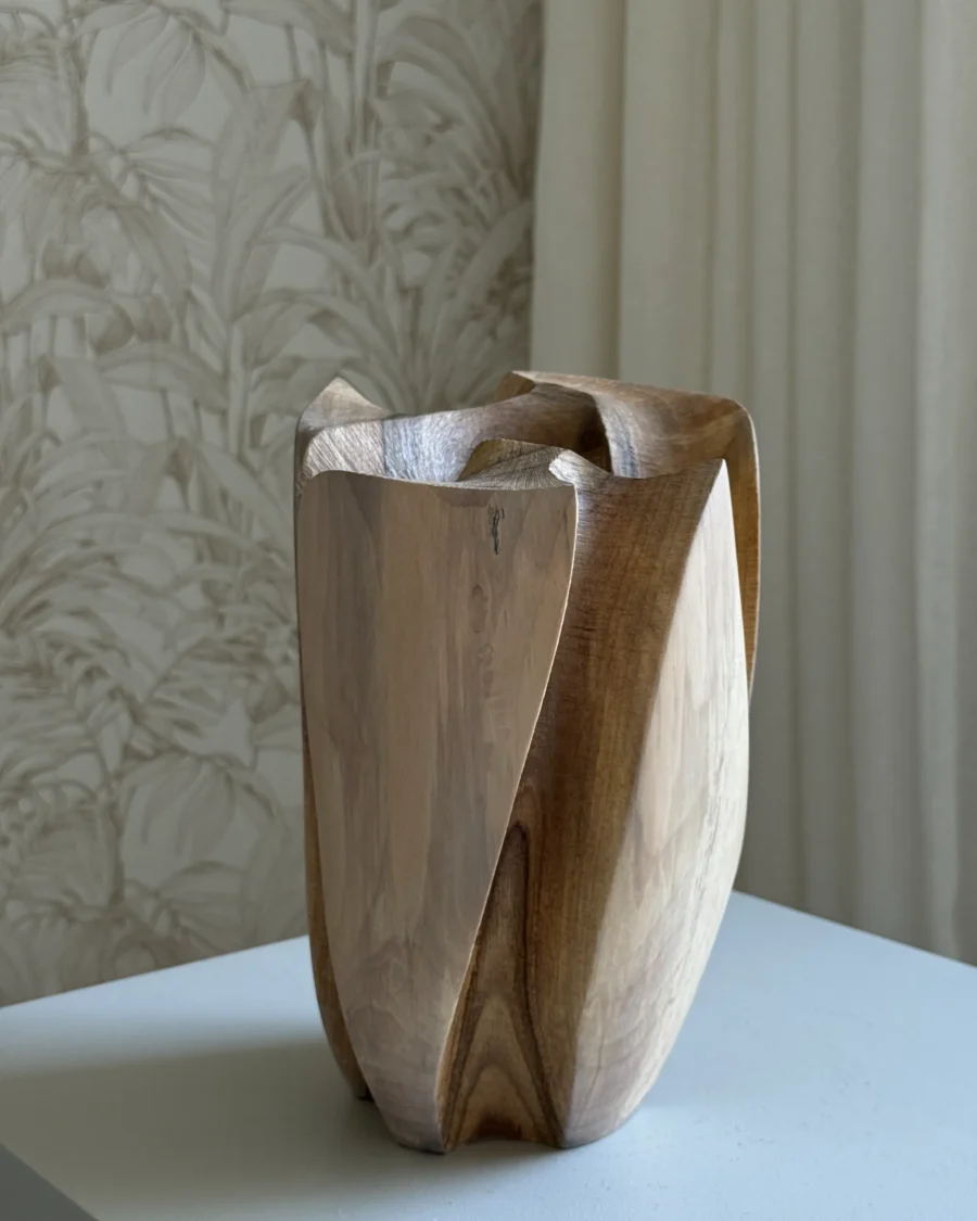 Rear view of Within with broad smooth walnut surfaces, narrow dark recesses and an irregular sculptural rim.
