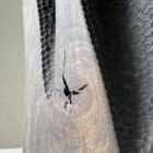 Close-up of a natural crack intentionally left open in the darkened applewood surface of Construct.