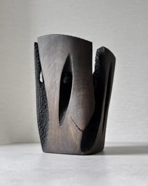 Front view of Construct showing a natural open crack, dark applewood finish and deep hand-carved recesses.
