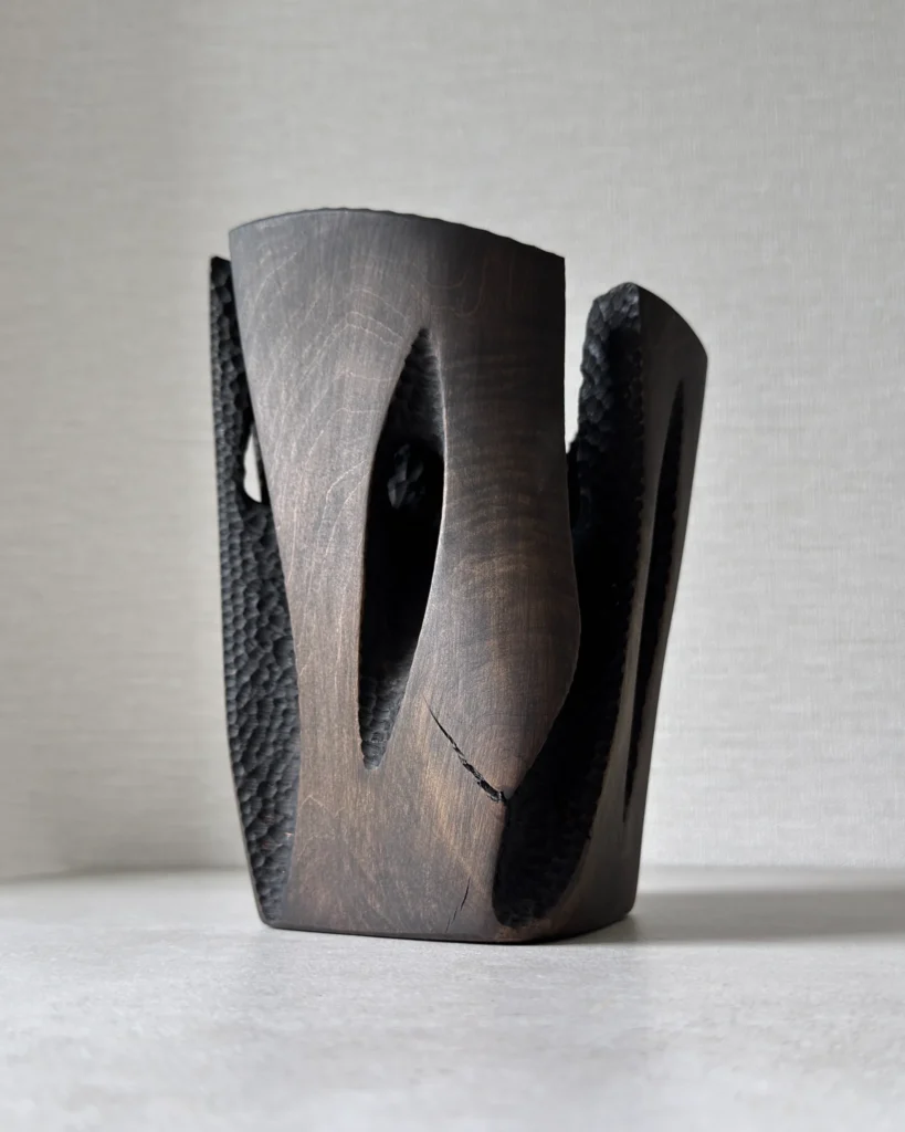 Front view of Construct showing a natural open crack, dark applewood finish and deep hand-carved recesses.
