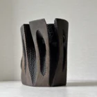 Construct modern wood vase showing layered carved panels, dark textured surfaces and visible applewood grain.