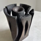 Top detail of Construct, a dark hand-carved applewood sculptural vase with textured openings around a central core.