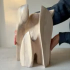 Hand-carved walnut sculpture Embrace shown with the artist’s hands to demonstrate its scale and sculptural presence