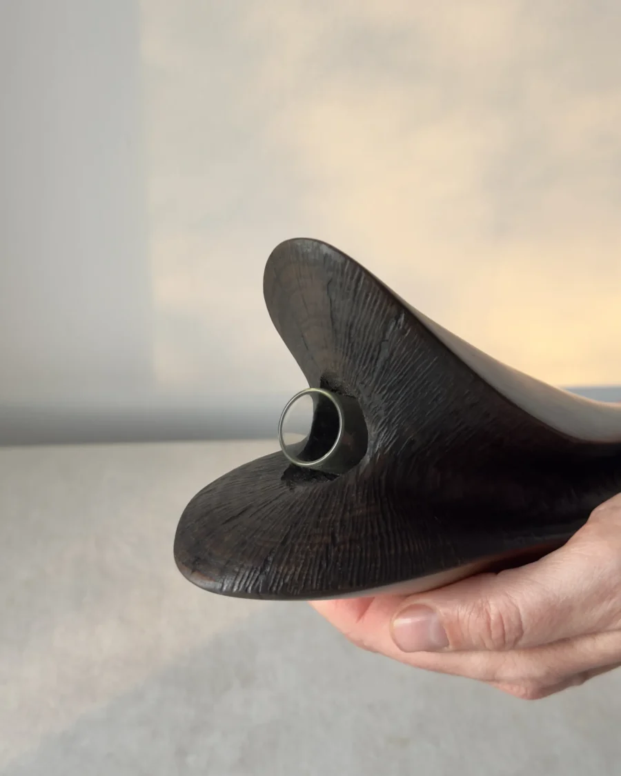 Close-up of the removable glass water tube fitted inside the textured top of the hand-carved cherry wood vase.