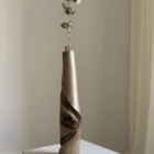 quiet-turn-sculptural-vase-dried-thistle Tall walnut wood vase Quiet Turn with a single dried thistle stem, showing its narrow sculptural proportion and soft natural light.