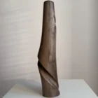 quiet-turn-sculptural-walnut-vase-side-view Side view of Quiet Turn, a hand carved walnut vase with a smooth tapered body and deep flowing carved recess.