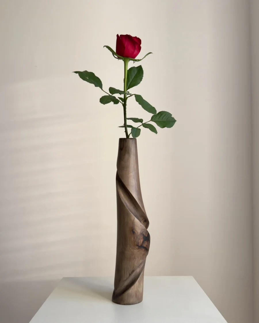 quiet-turn-walnut-vase-red-rose-front-view Tall walnut wood vase Quiet Turn with a red rose, showing its slender sculptural form and carved diagonal movement.