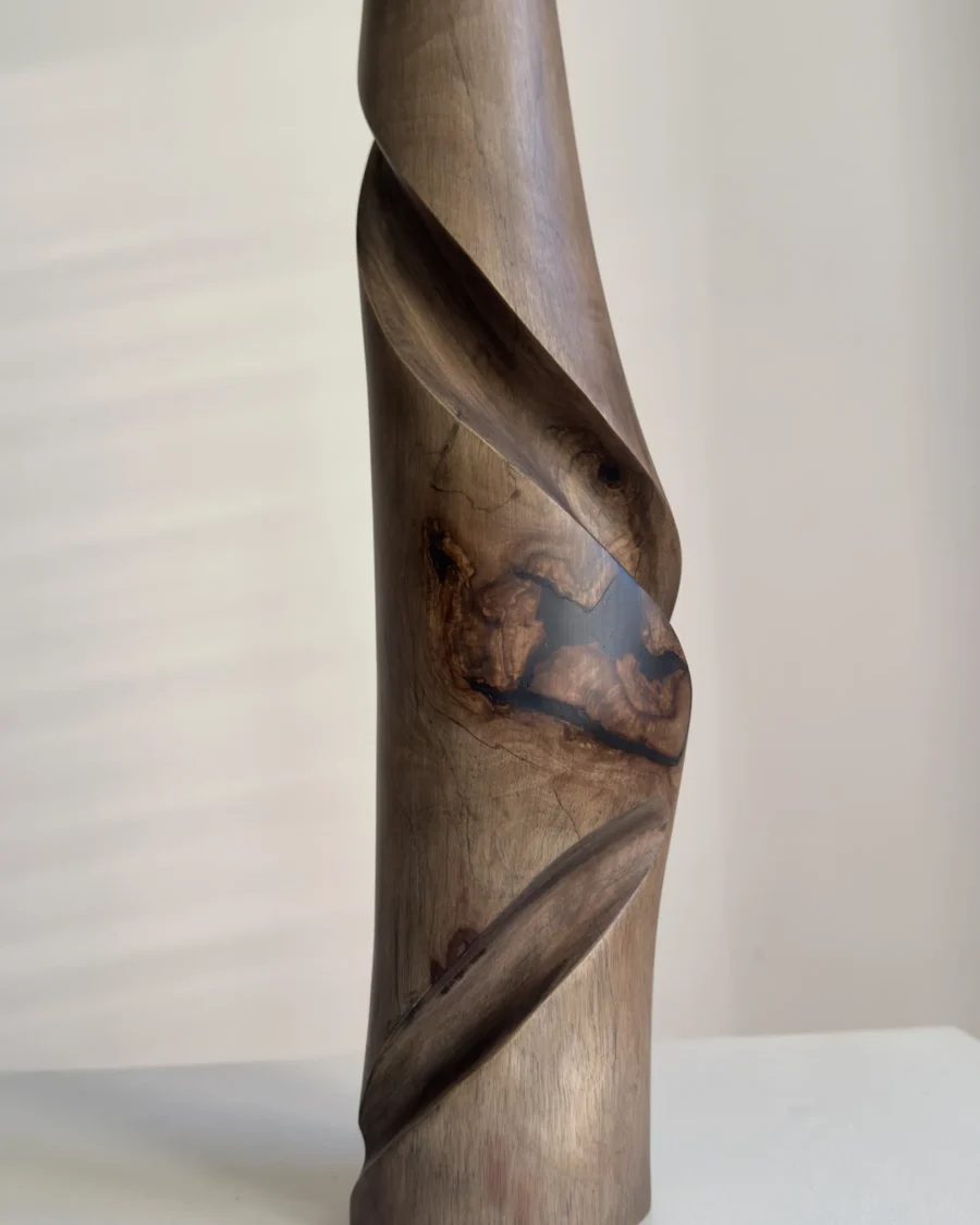 quiet-turn-walnut-vase-resin-close-u Close-up of the central black resin inclusion in Quiet Turn, surrounded by natural walnut grain and smooth hand carved surfaces.